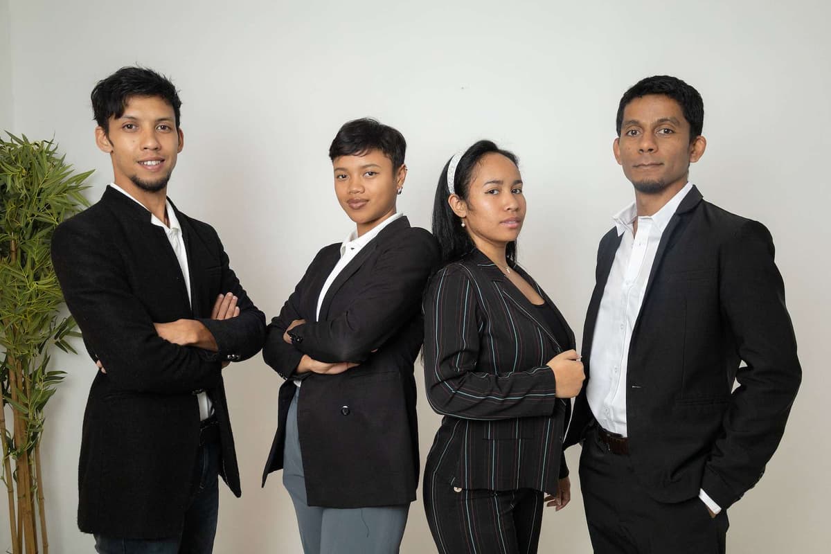 Quatre collaborateurs en tenue professionnelle